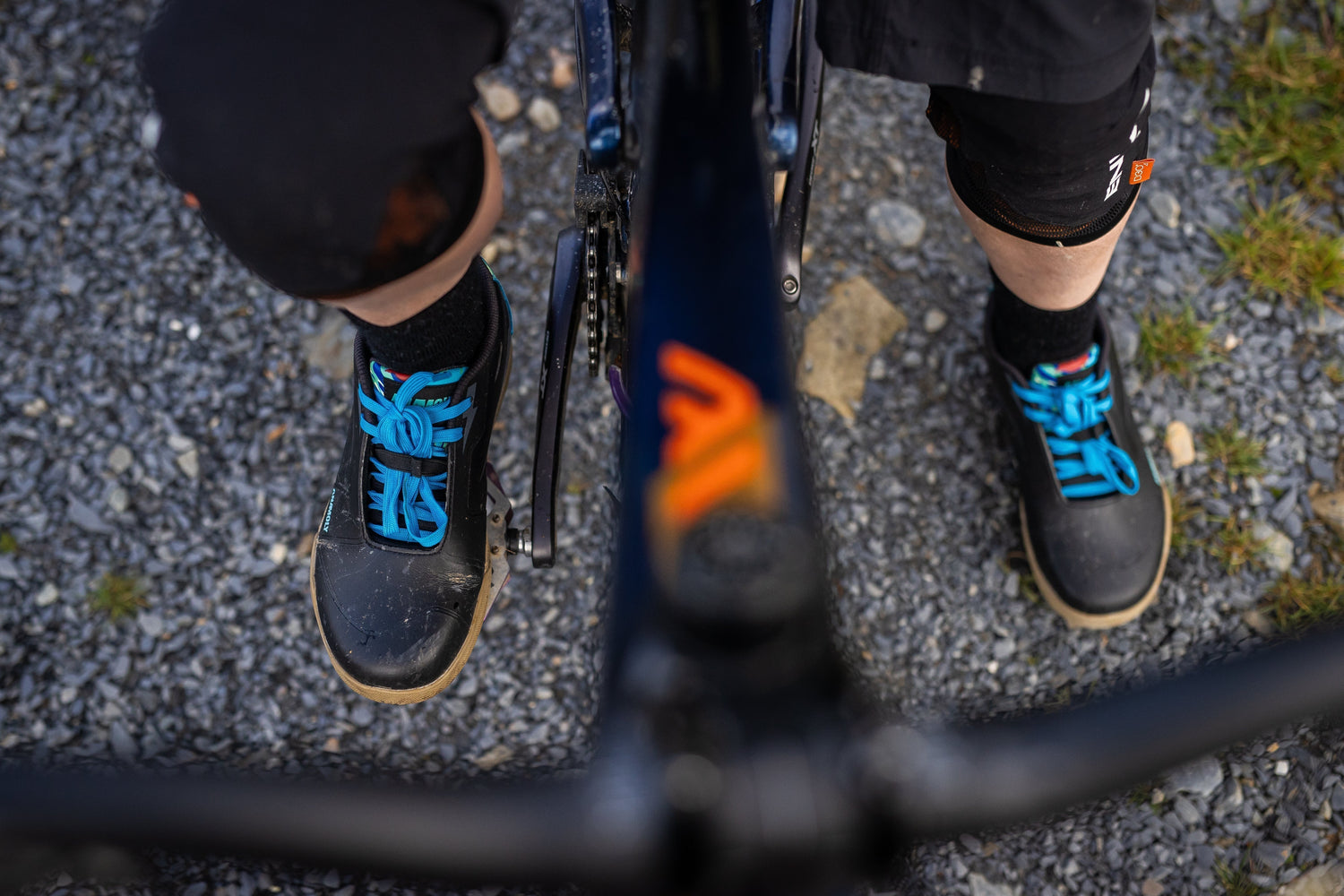 Wide mountain bike shoe on flat pedal showing natural toe splay on technical trail