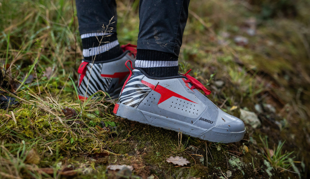 Skate-style flat-pedal mountain bike shoe on a technical trail