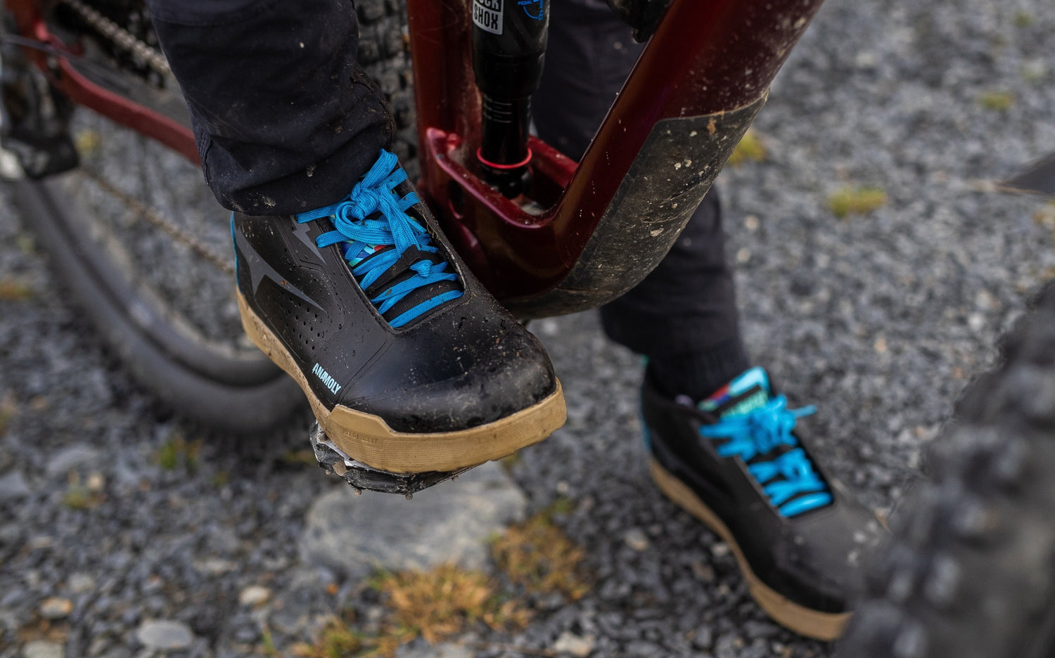 Mountain bike flat pedal shoe with extra-wide toe box on rocky trail terrain